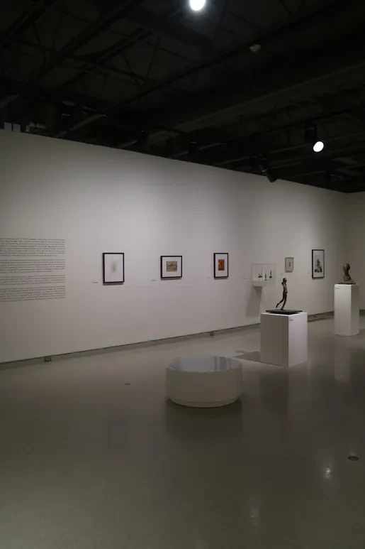 Fresno Art Museum — gallery wall with framed works and bronze figure on pedestal