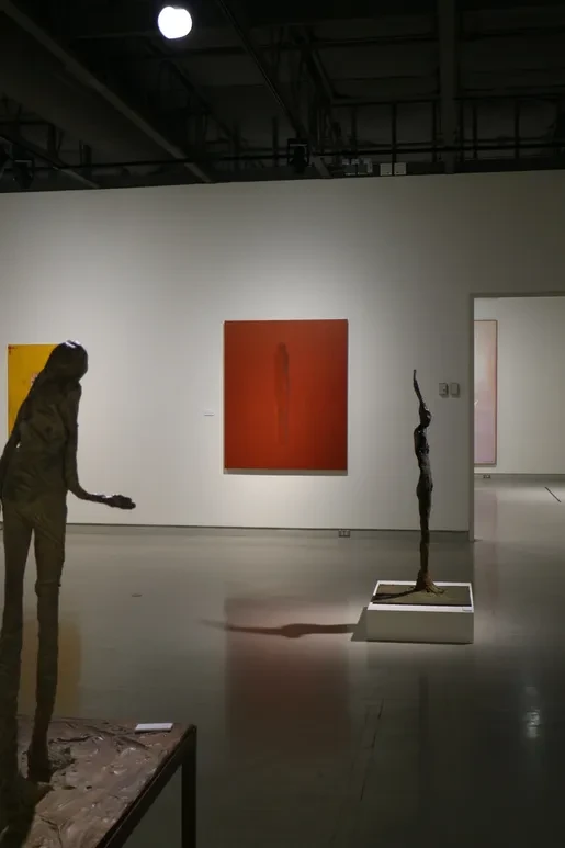 Fresno Art Museum — gallery corridor with bronze figure sculpture and portrait photograph of Nathan Oliveira