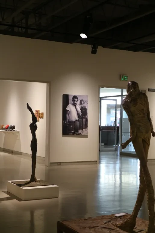 Fresno Art Museum — two bronze figures with portrait photograph on gallery wall