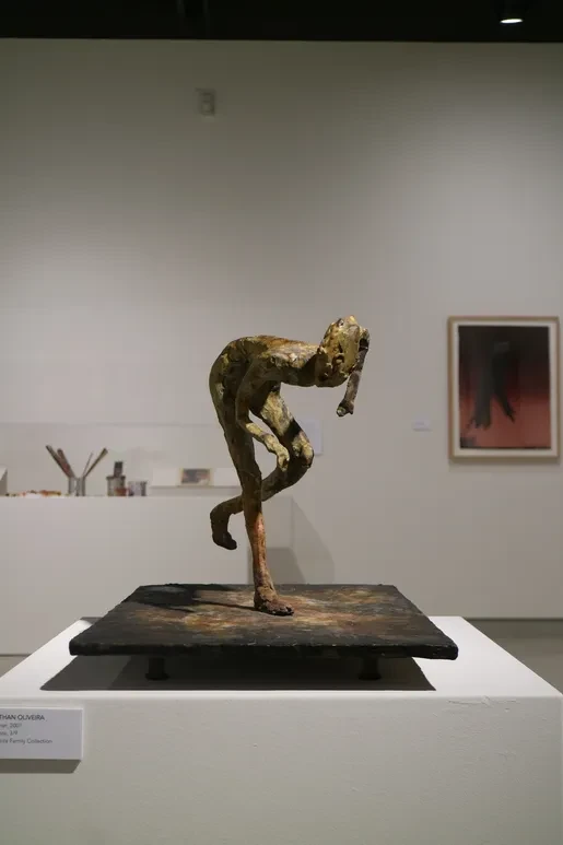 Fresno Art Museum — bronze figure sculpture leaning forward on black base with framed artwork behind