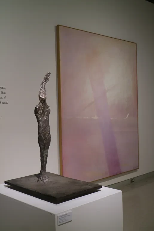 Fresno Art Museum — tall silver bronze figure with arm raised before large pink and lavender canvas