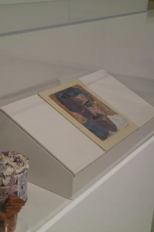 Fresno Art Museum — small figurative painting displayed on white pedestal in display case
