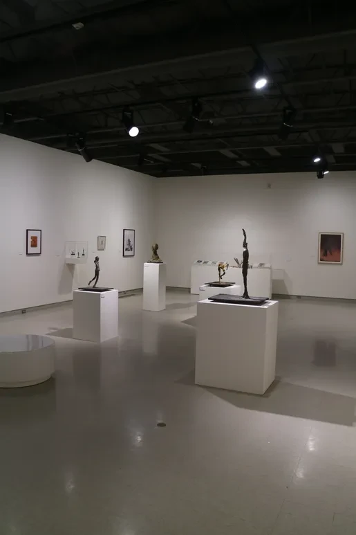 Fresno Art Museum — multiple bronze sculptures on pedestals with framed works