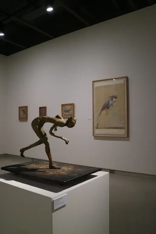 Fresno Art Museum — gallery corridor with framed works including large figurative drawing