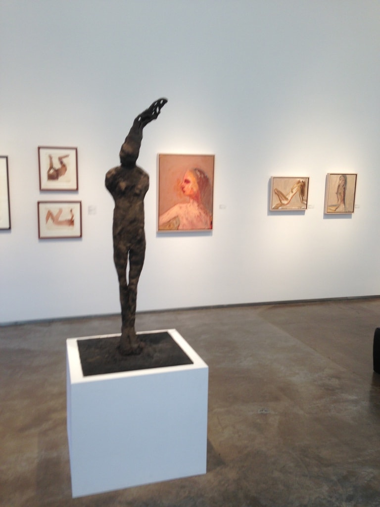 LewAllen Gallery — bronze figure sculpture on white pedestal with figurative paintings and drawings