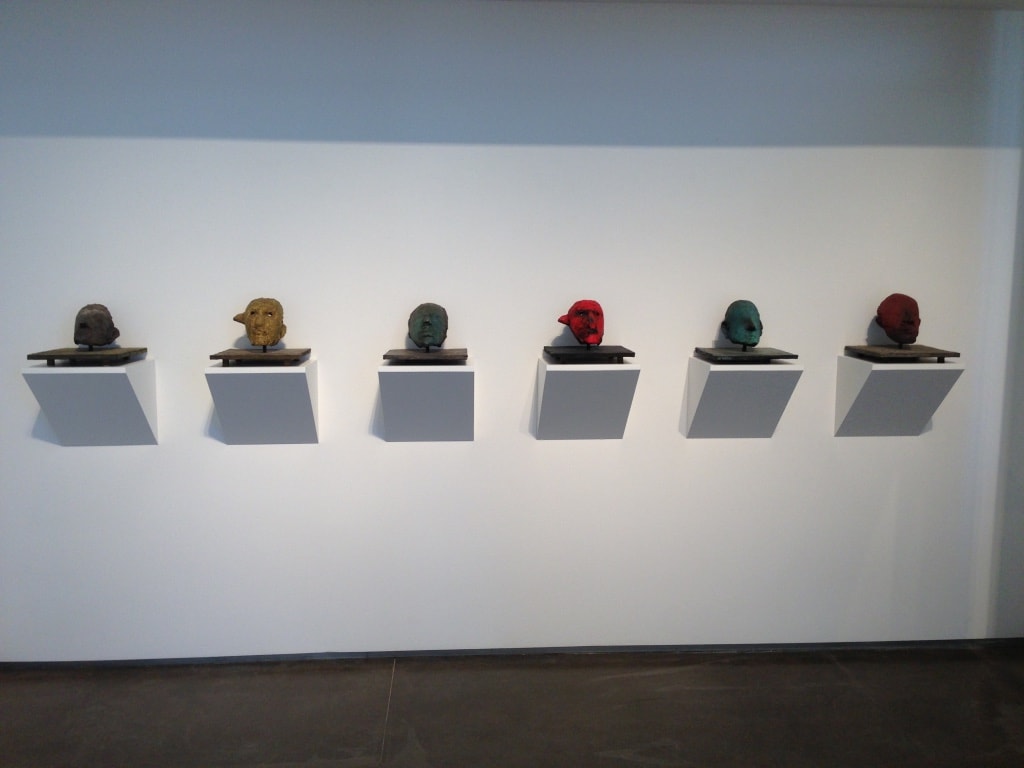 LewAllen Gallery — close-up of six colorful sculptural heads on wall-mounted shelves