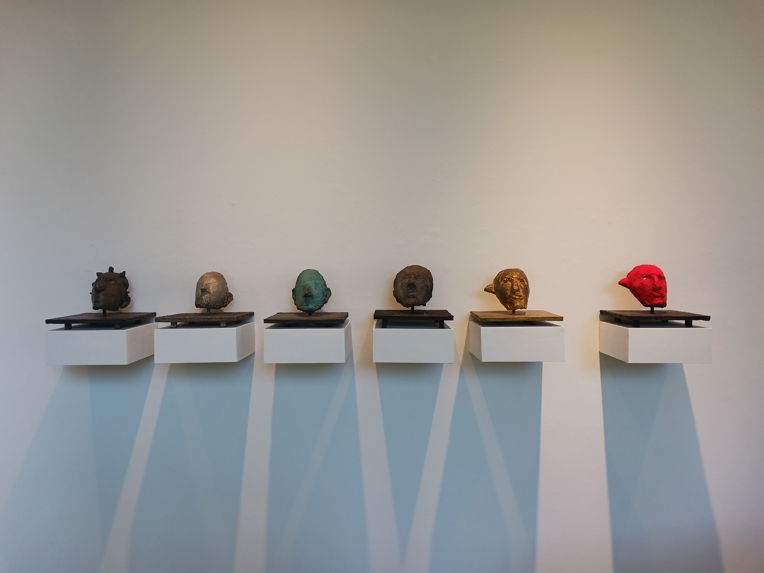 Triton Museum of Art — six sculptural heads on white pedestals with varied patinas