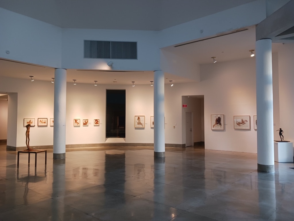 Triton Museum of Art — gallery entrance wall with framed works and bronze figure sculpture